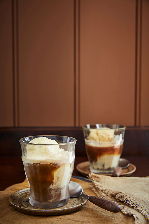 Zwei Tassen mit Affogato vor brauner Wand