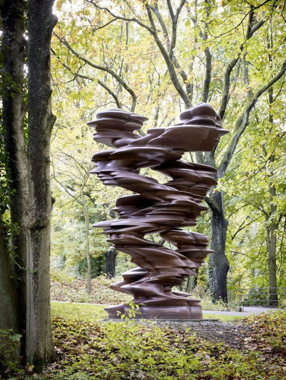 Eine geschwungene Bronzeskulptur auf einer Waldlichtung