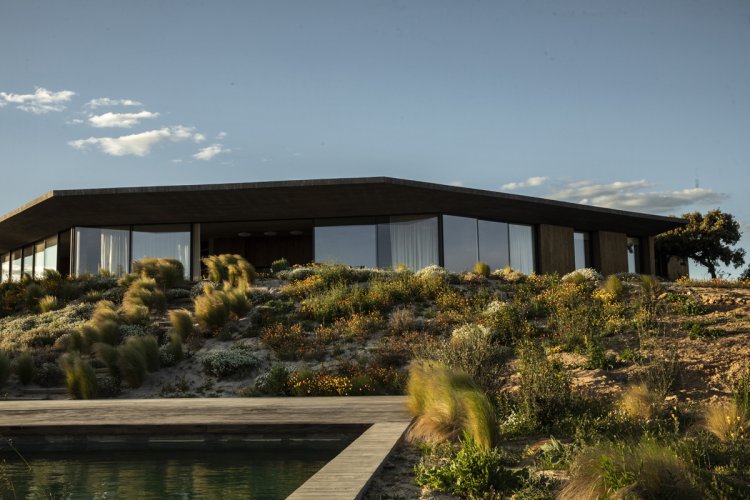 Aussenansicht Haus Fonte das Perdizes mit Pool in hügeliger Landschaft.