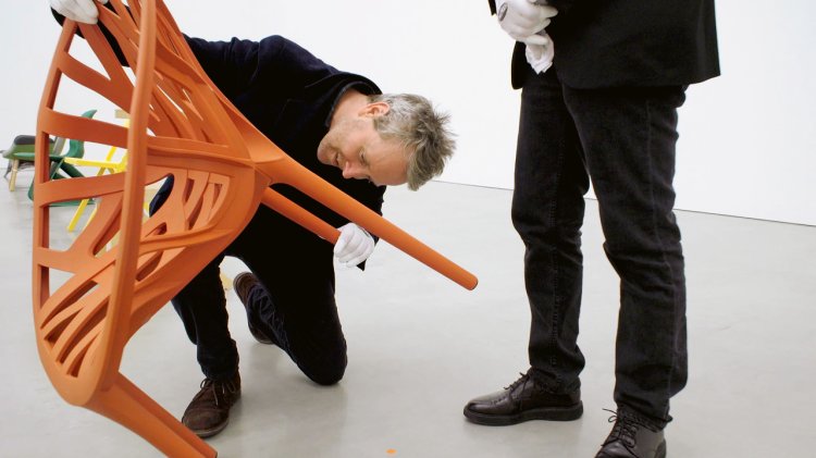 Ronan Bouroullec mit seinem orange farbenen Stuhl Vegetal.
