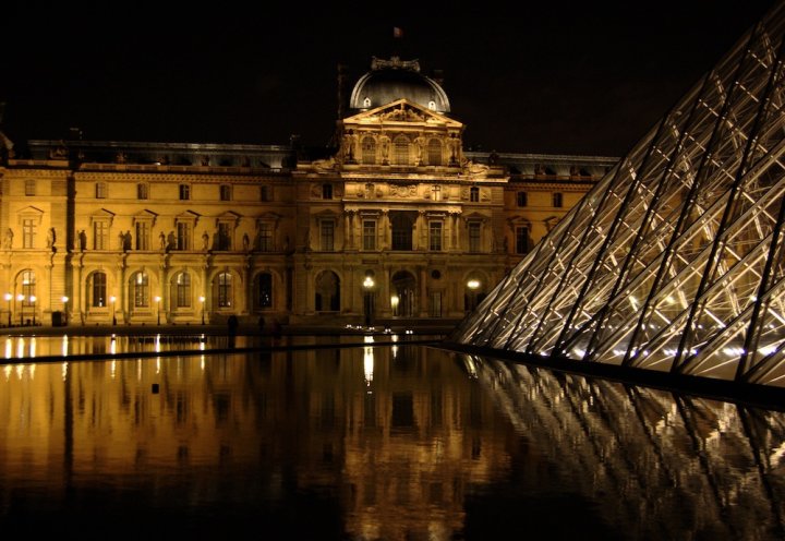 Beleuchtetes Louvre Museum in Paris bei Nacht.