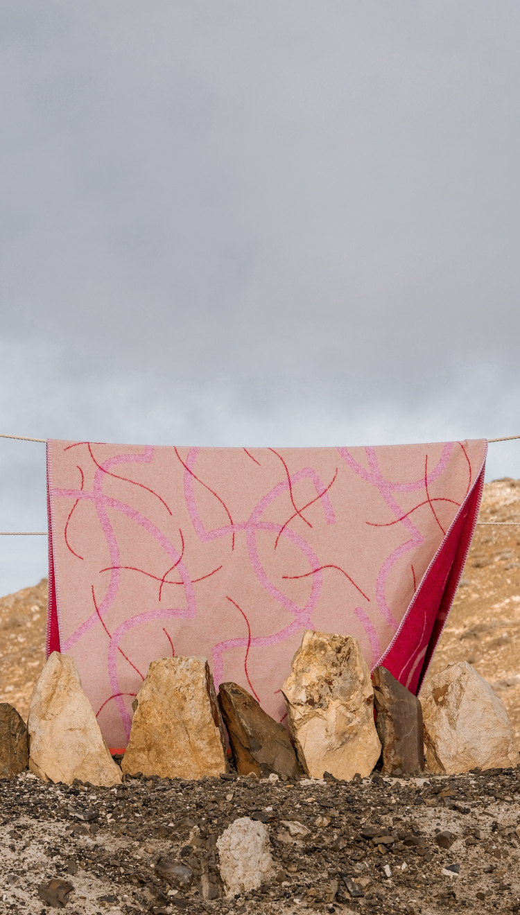 Rosa-pink gemusterte Decke von Maria Jeglinska aufgehängt an einem Sandstrand.