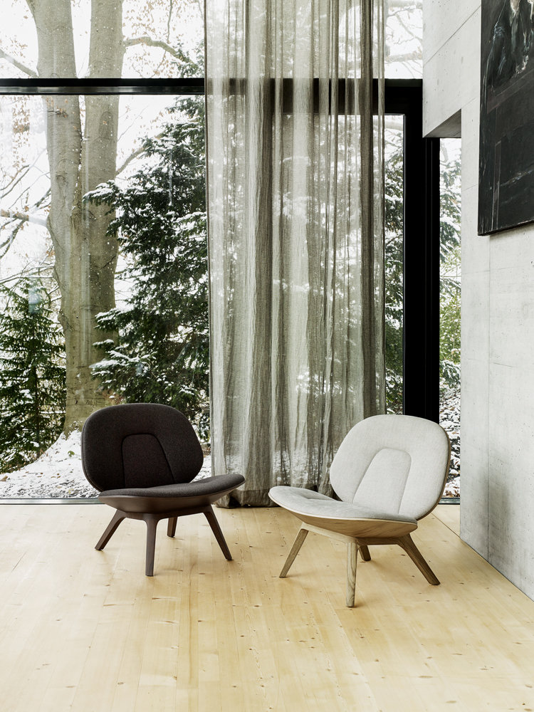 Sessel Poi in schwarz und beige vor einem grossen Fenster mit durchsichtigen Vorhang.