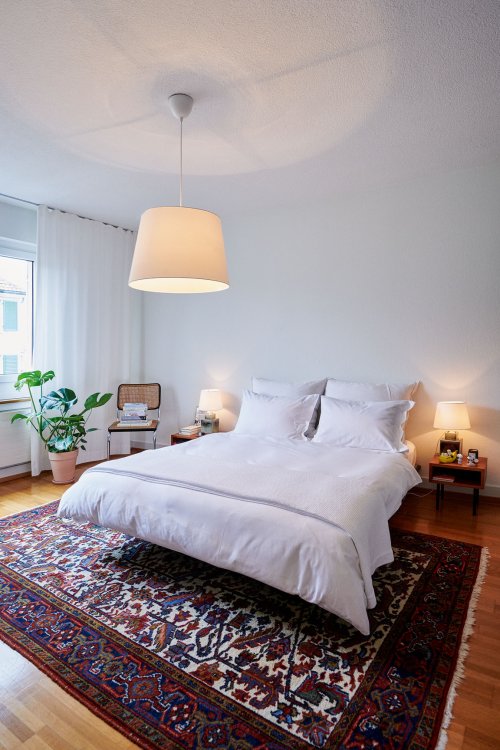 Schlafzimmer mit weissem Bettüberwurf von Schlossberg.