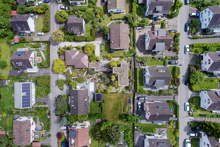 Aufnahme aus der Vogelperspektive von einem Wohnquartier mit Einfamilienhäusern und viel Grün.