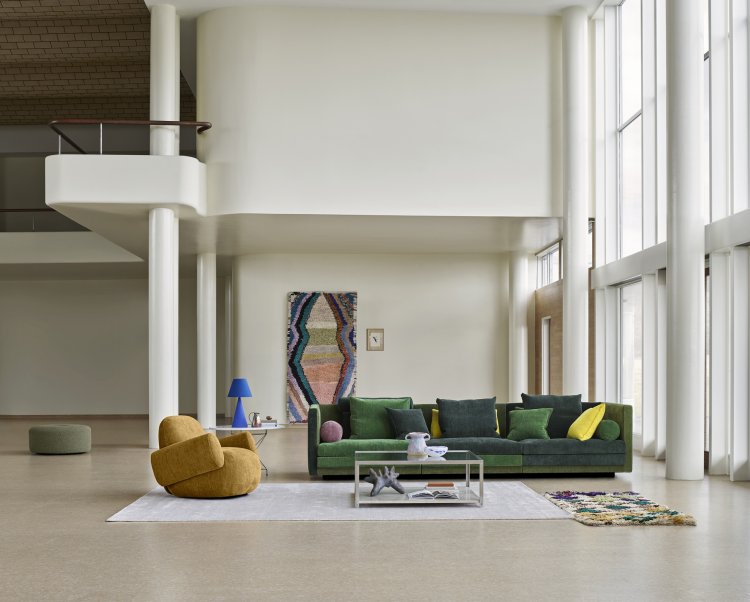 Gelber Sessel und grünes Cocoon Sofa von Eilersen in einem grosszügigen hellen Industrieraum.