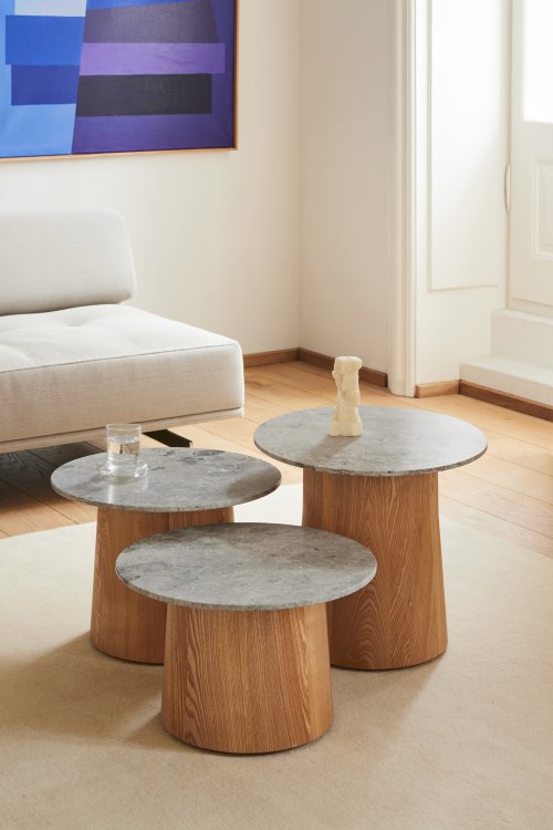 Drei unterschiedlich hohe runde Coffeetable von Federicia Furniture mit rundem Holzsockel und grauer Steinplatte.
