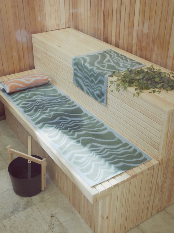 Sauna mit zwei Strandtücher in Türkis und Wasserkübel.