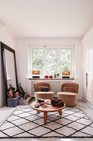 Zwei Sessel stehen in einem hellen Zimmer, mit Fenster und Beistelltisch.