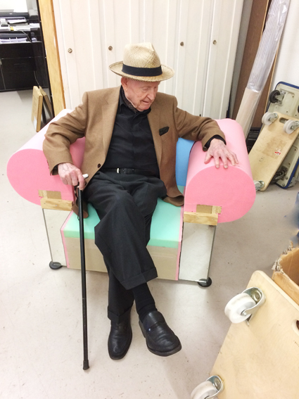 Robert Haussmann, elegant gekleidet, sitzt im 1:1-Prototypen des neuen Sessels.