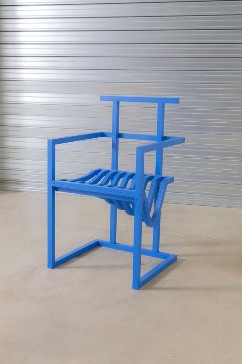 Der Stuhlentwurf von Benjamin Edgar für das Projekt 19 Chairs zeigt ein königsblau gestrichenen Stuhl, dessen Sitzfläche zur linken Seite hin abfällt.
