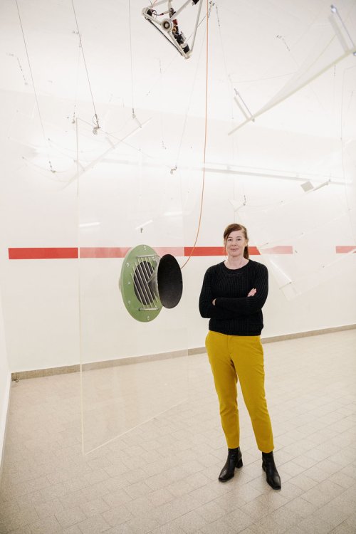 Die Textildesignerin Annette Douglas in schwarzem Pullover und senfgelber Hose steht in einer Forschungshalle der ETH Zürich.