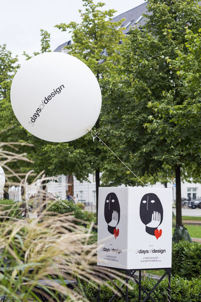 Ein Plakat und ein weisser Ballon mit dem Schriftzug und Logo der "3 days of design" sind vor einer grünen Allee fotografiert.