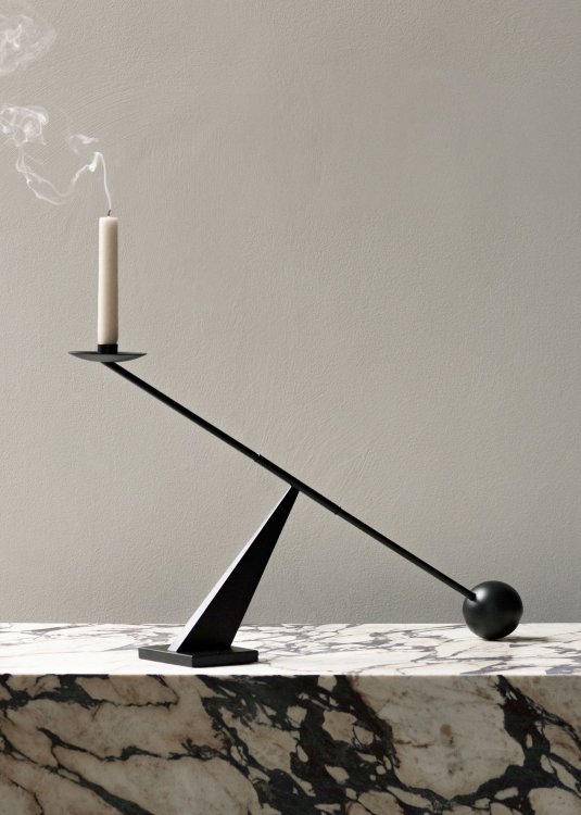 Ein skulpturaler Kerzenständer aus schwarzem Messing der sich aus geometrischen Formen einer Kugel und einer Geraden, die sich zu einem einzigartigen Design vereinen, zusammensetzt.