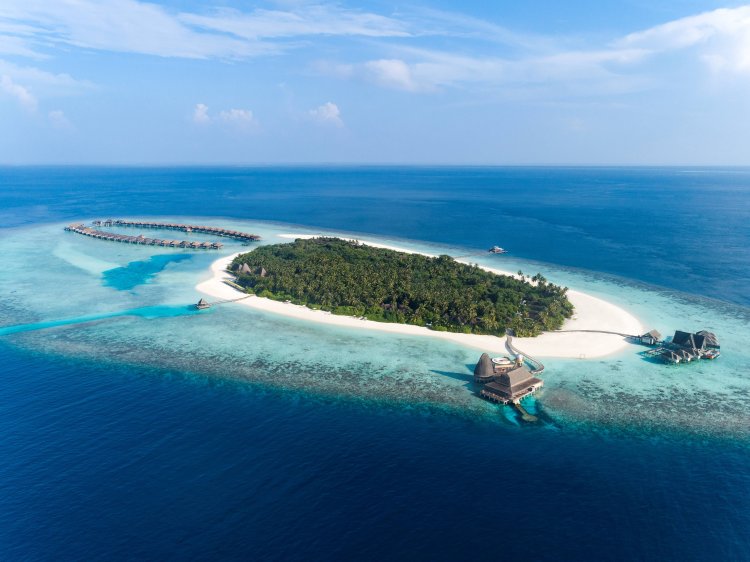 Luftaufnahme des «Anantara Kihavah Maldives Villas» Resorts das auf einer exklusiven grünen Insel inmitten des Türkisen Indischen Ozeans liegt.