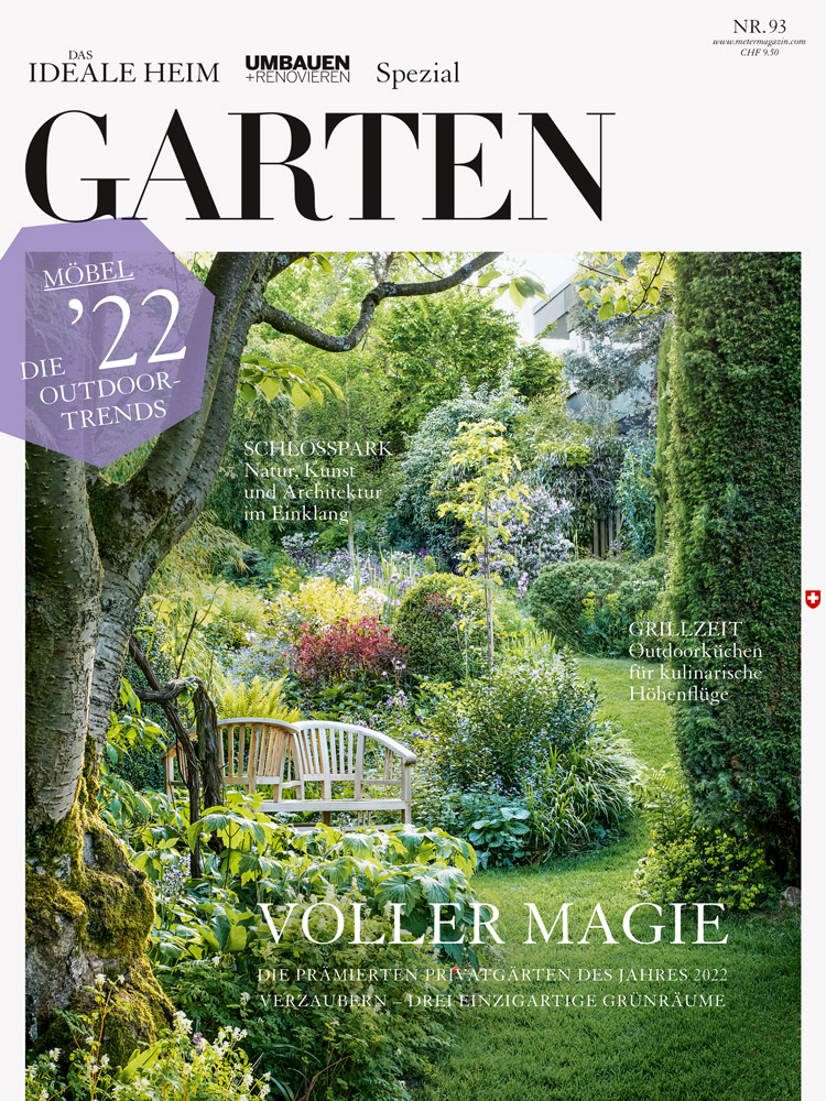 Cover der Spezialausgabe GARTEN zeigt einen verwunschenen, üppig grünen Garten, in dem unter einem hohen Baum eine hölzerne Parkbank steht.
