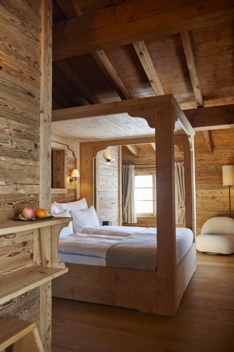 Ein komplett in Holz ausgestattetes Chalet-Zimmer mit Himmelbett im Luxushotel Berghaus Radons.